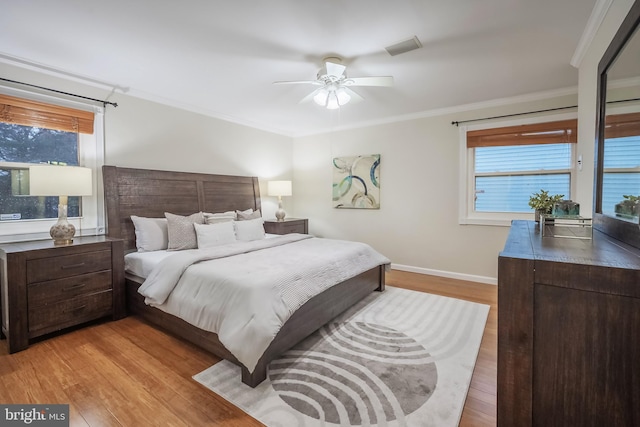 bedroom with light wood-type flooring, ceiling fan, and crown molding