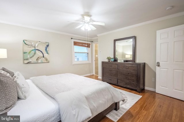 bedroom with ceiling fan, crown molding, and wood-type flooring