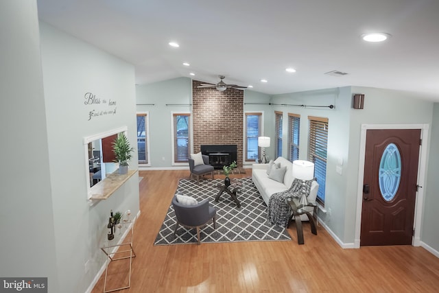 living room featuring ceiling fan, light hardwood / wood-style floors, and lofted ceiling