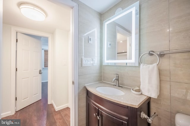 bathroom with vanity, wood-type flooring, tile walls, and toilet