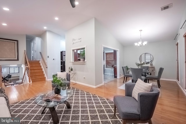 living room featuring a chandelier, plenty of natural light, high vaulted ceiling, and wood-type flooring