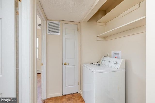 washroom with washer / dryer, a textured ceiling, and light parquet flooring