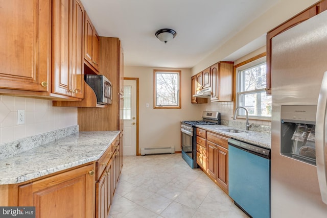 kitchen featuring baseboard heating, light stone counters, sink, and stainless steel appliances