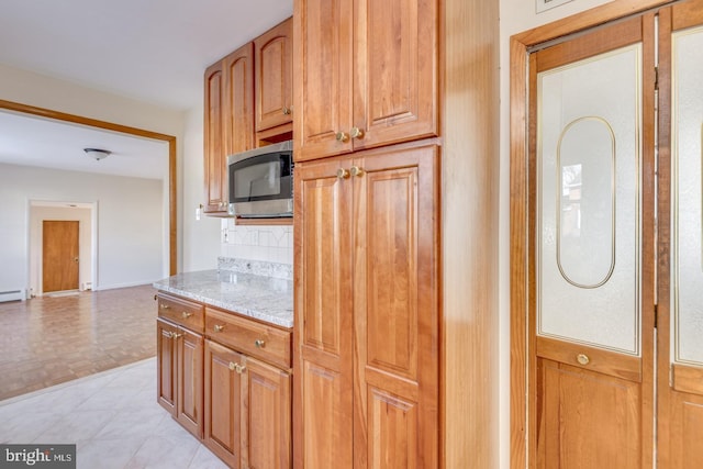 kitchen featuring backsplash and light stone countertops