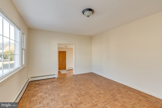 empty room with baseboard heating and light parquet flooring