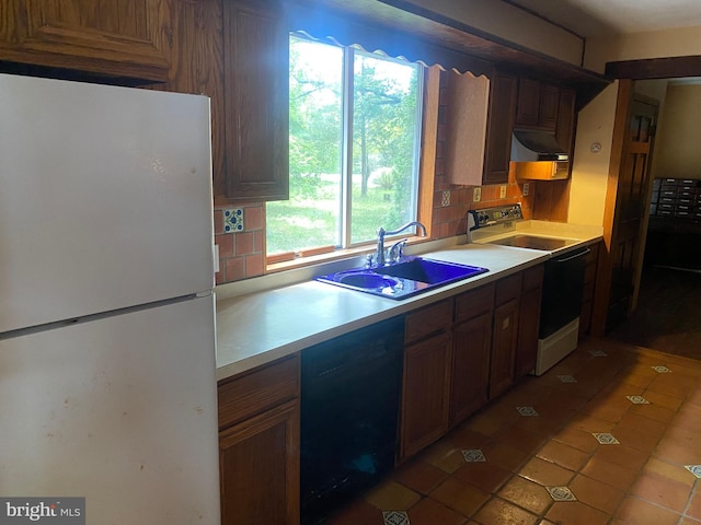 kitchen with backsplash, tile patterned floors, white appliances, extractor fan, and sink