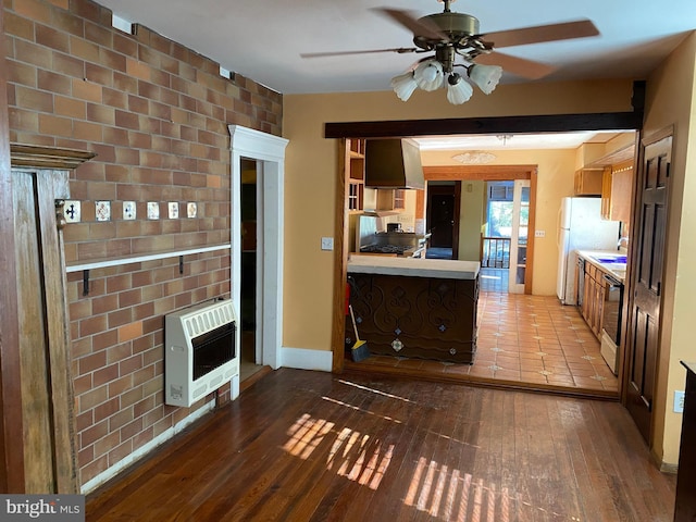 kitchen featuring heating unit, ceiling fan, stainless steel range oven, and hardwood / wood-style flooring