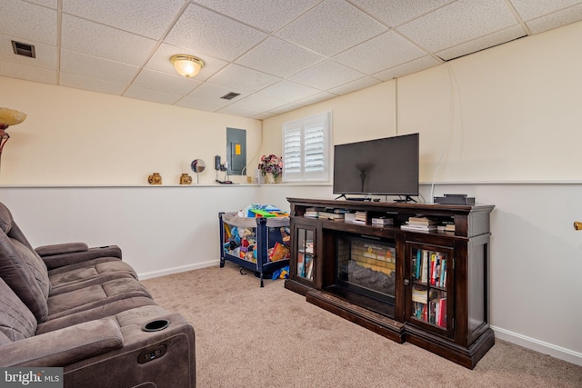 living room with carpet floors, electric panel, and a paneled ceiling