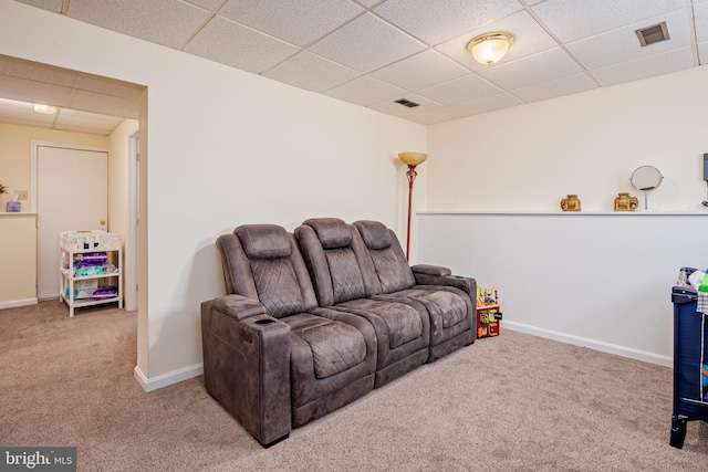 living room featuring carpet floors and a paneled ceiling