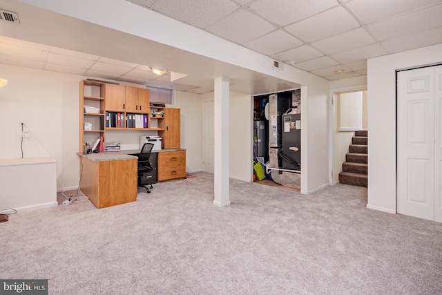 carpeted office featuring a paneled ceiling and water heater