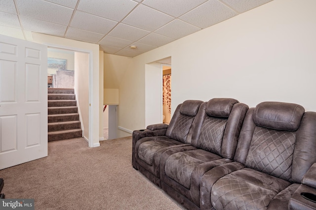 living room featuring carpet floors and a paneled ceiling