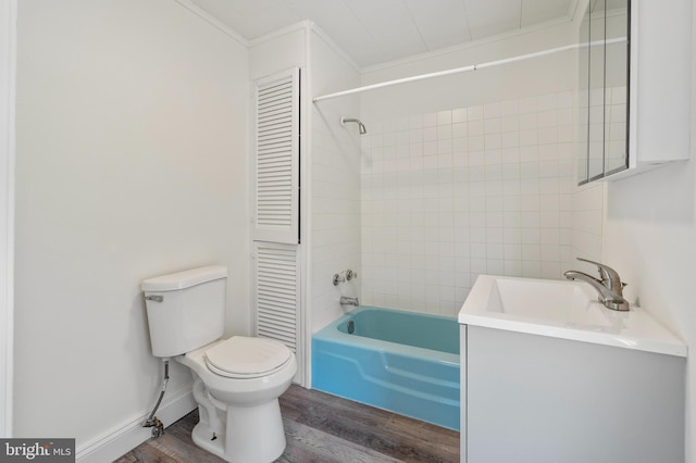 full bathroom featuring hardwood / wood-style floors, toilet, tiled shower / bath, and ornamental molding