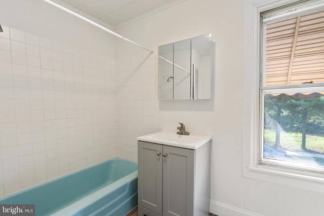 bathroom with tiled shower / bath combo, crown molding, and vanity