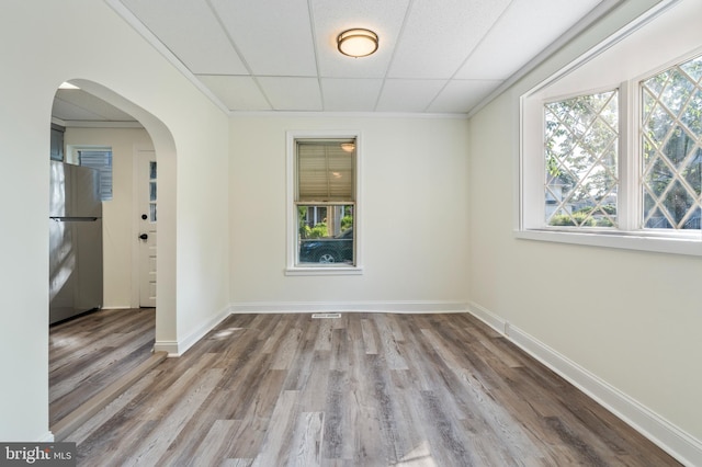 unfurnished room featuring hardwood / wood-style floors, a paneled ceiling, and crown molding