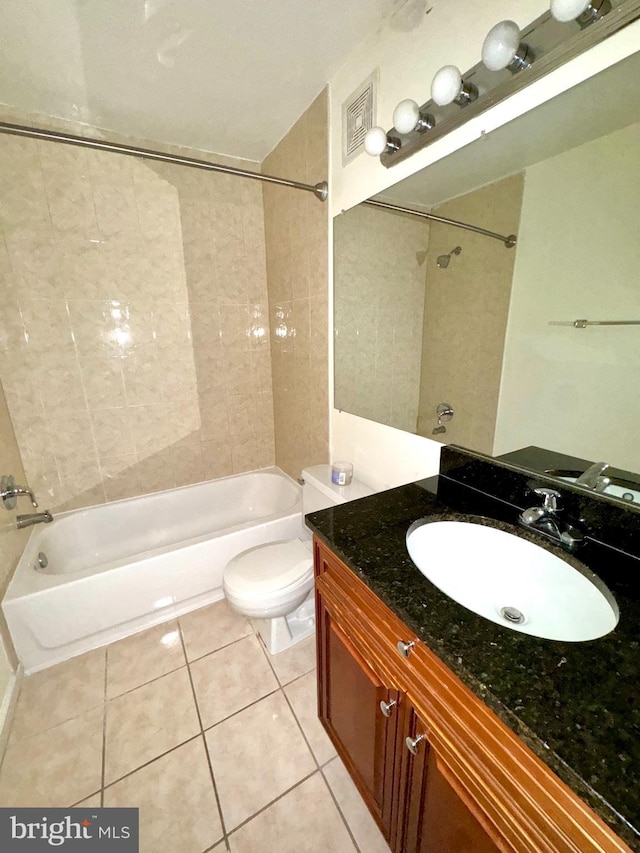 full bathroom featuring tile patterned floors, vanity, toilet, and tiled shower / bath combo