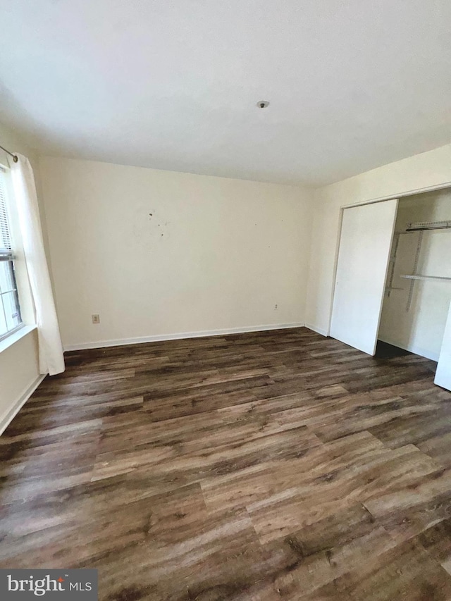 unfurnished bedroom with dark wood-type flooring