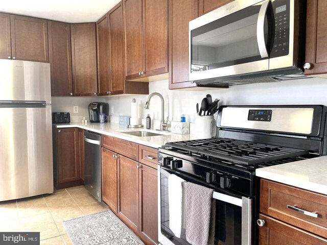 kitchen featuring sink, light tile patterned floors, and stainless steel appliances