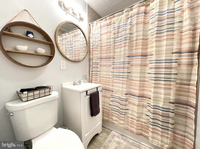 bathroom with toilet, vanity, and a shower with shower curtain