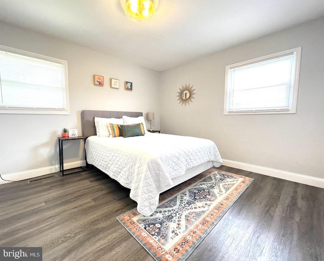 bedroom featuring multiple windows and dark wood-type flooring