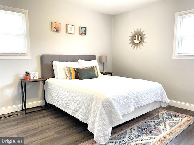 bedroom featuring dark hardwood / wood-style flooring and multiple windows