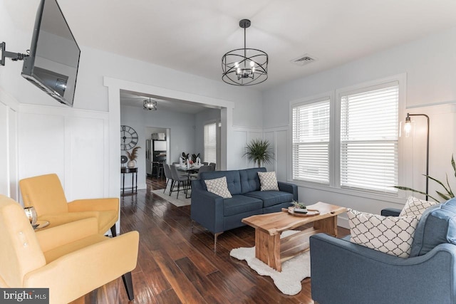 living room featuring a notable chandelier and dark hardwood / wood-style floors