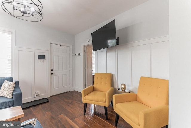 living area with dark hardwood / wood-style floors and a notable chandelier