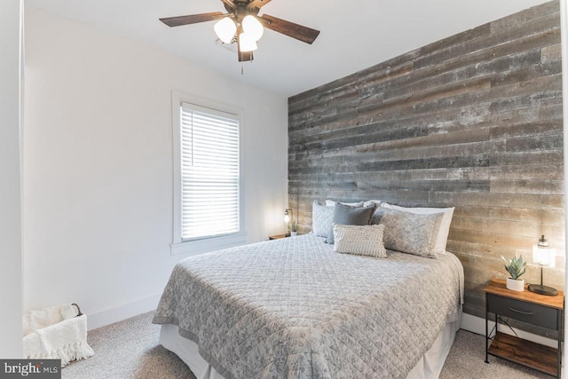 bedroom featuring ceiling fan, carpet, and wood walls