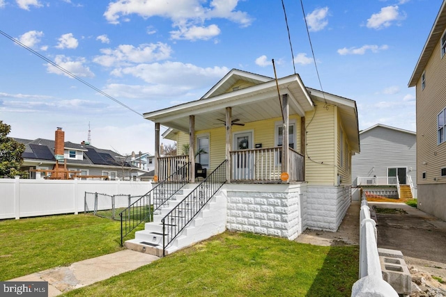 bungalow-style home featuring covered porch and a front lawn