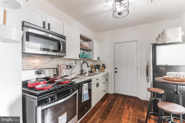 kitchen featuring sink, dark hardwood / wood-style floors, backsplash, white cabinets, and appliances with stainless steel finishes