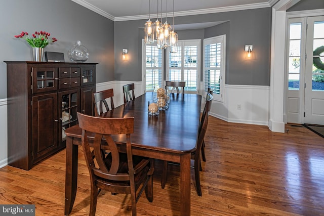 dining space featuring a chandelier, hardwood / wood-style flooring, and crown molding