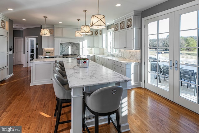 kitchen with backsplash, a center island, pendant lighting, and french doors