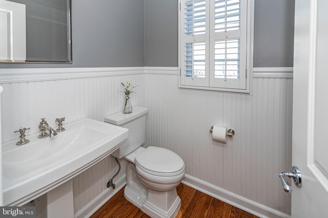 bathroom with hardwood / wood-style floors, toilet, and sink