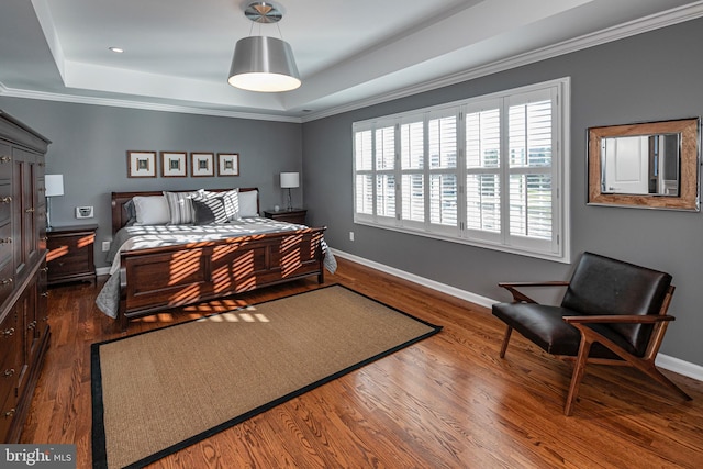 bedroom with crown molding, a raised ceiling, and dark wood-type flooring