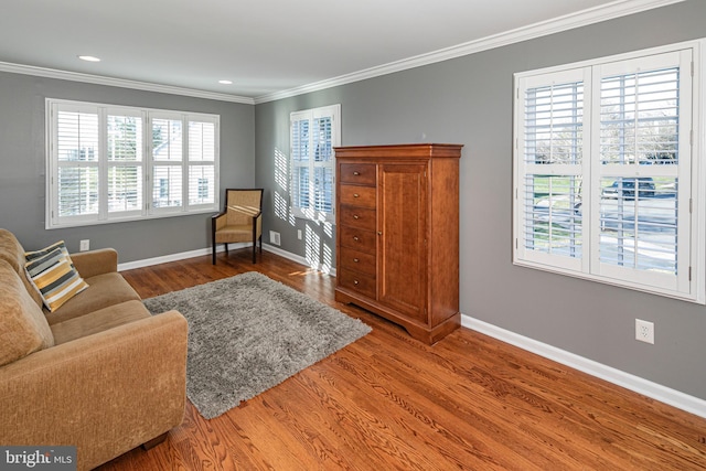 living area with hardwood / wood-style flooring and crown molding