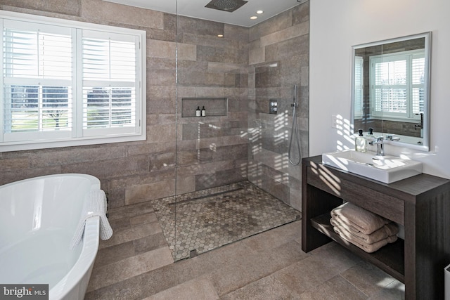 bathroom featuring vanity, separate shower and tub, and tile walls