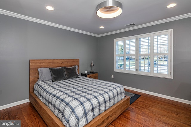 bedroom with dark hardwood / wood-style floors and crown molding