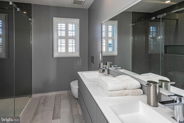 bathroom with vanity, toilet, and a shower with shower door