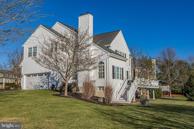 back of house featuring a wooden deck, a yard, and a garage