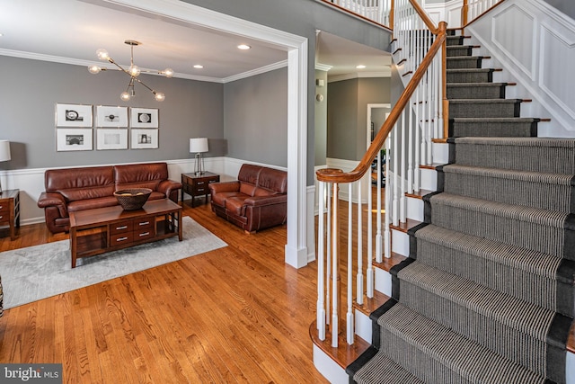 living room featuring light hardwood / wood-style floors, an inviting chandelier, and crown molding