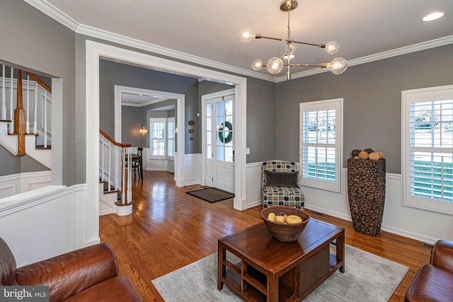 living room featuring hardwood / wood-style flooring, crown molding, and a chandelier