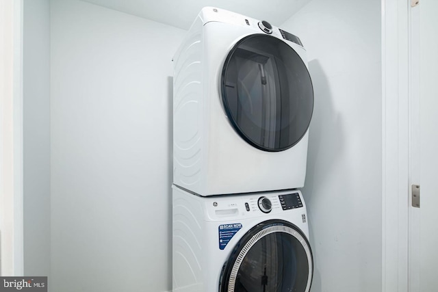 washroom featuring stacked washer / dryer