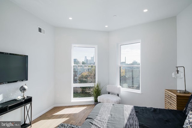 bedroom with multiple windows and light wood-type flooring