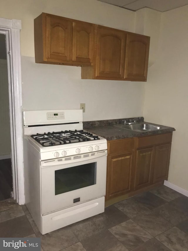 kitchen featuring sink and white range with gas stovetop