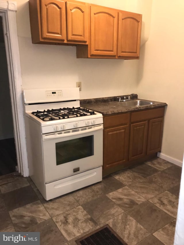 kitchen with white gas stove and sink