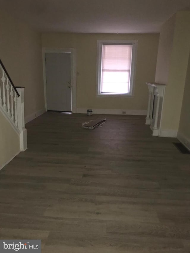 unfurnished living room with dark hardwood / wood-style flooring