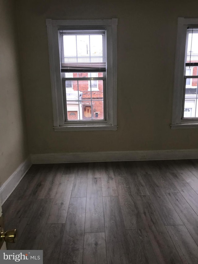 unfurnished room with dark wood-type flooring