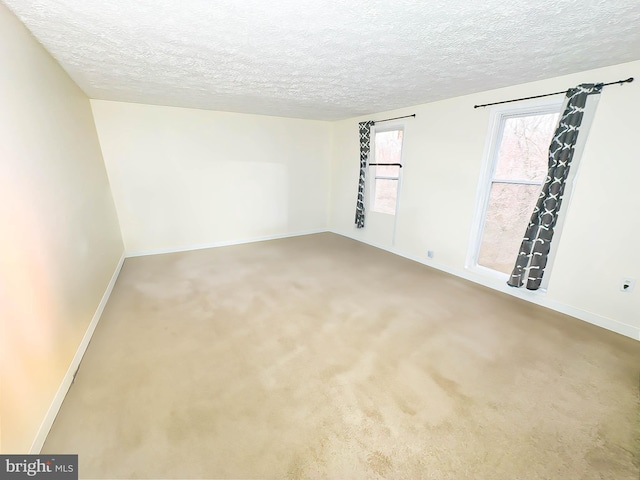 carpeted empty room with a textured ceiling