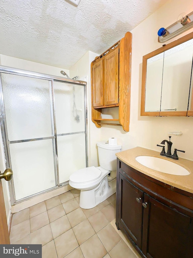 bathroom featuring tile patterned floors, vanity, toilet, and a textured ceiling