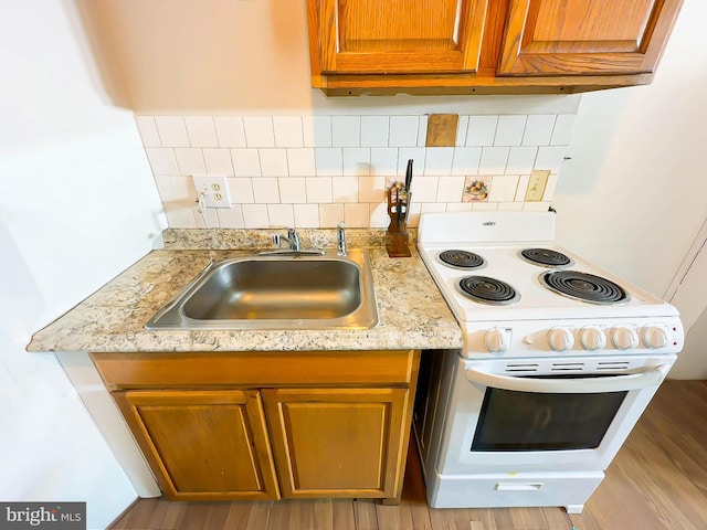 kitchen with sink, backsplash, light hardwood / wood-style flooring, and electric stove