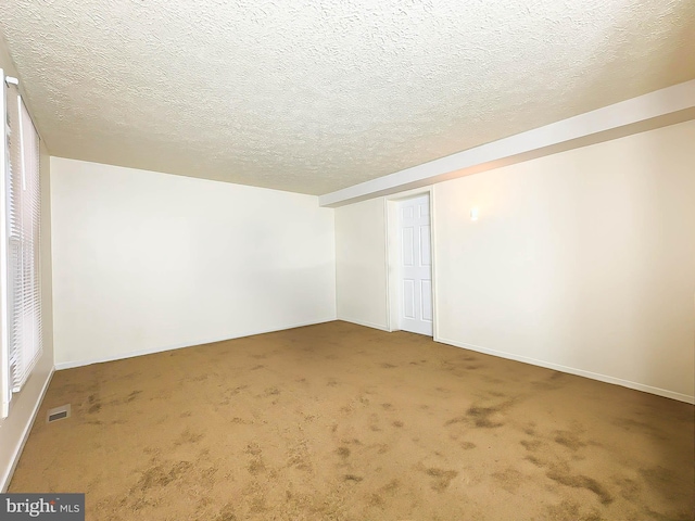 carpeted spare room with a textured ceiling